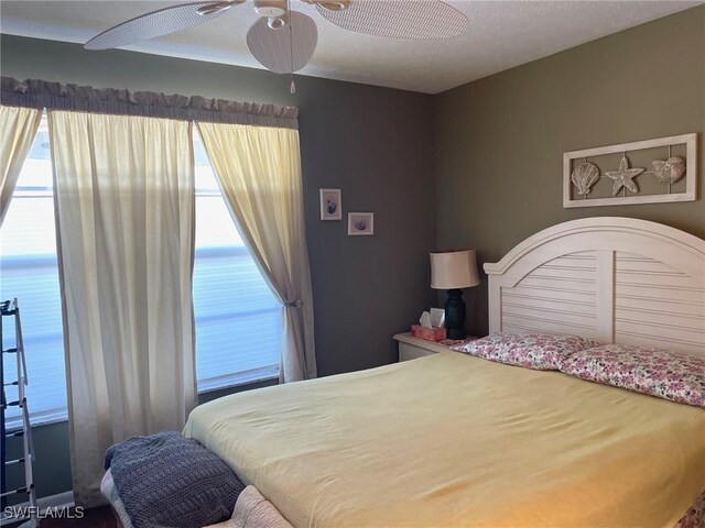 bedroom featuring a water view and ceiling fan