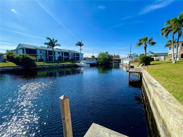 dock area featuring a lawn and a water view