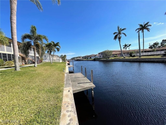 dock area featuring a residential view, a water view, and a lawn