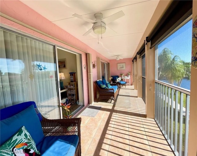 sunroom / solarium with a water view and ceiling fan