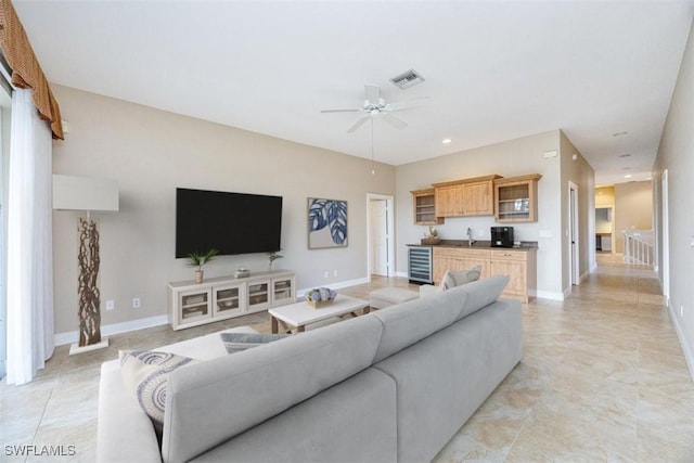 living room featuring ceiling fan, sink, and beverage cooler