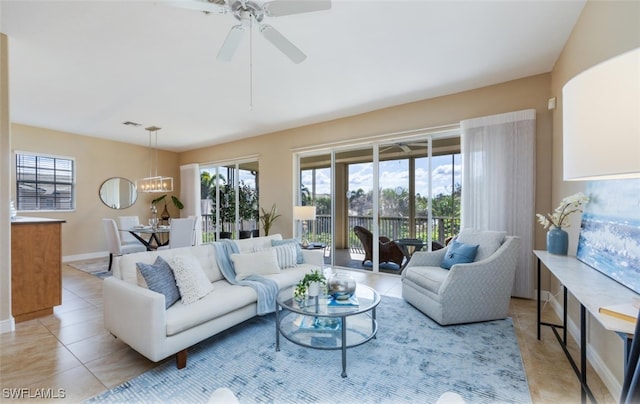 living room featuring light tile patterned flooring and ceiling fan with notable chandelier