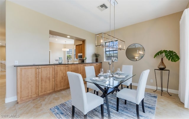 dining room with sink and a notable chandelier