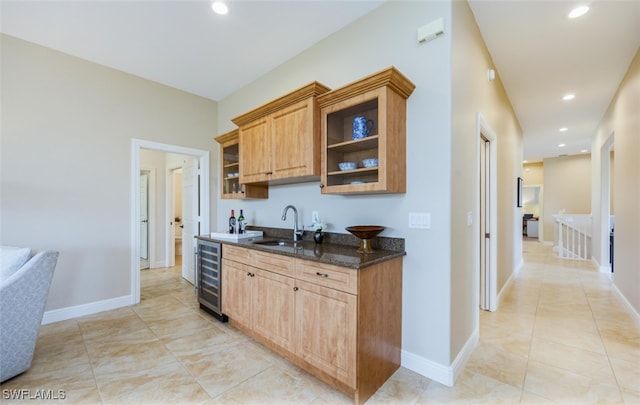 kitchen with sink, dark stone countertops, wine cooler, and light tile patterned floors