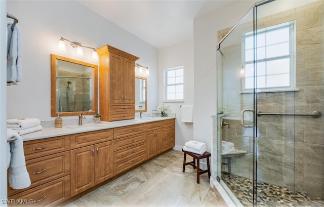 bathroom with vanity, a shower with shower door, and a wealth of natural light