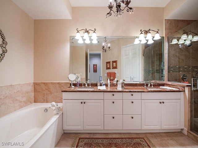 bathroom featuring tile patterned flooring, vanity, independent shower and bath, and a notable chandelier