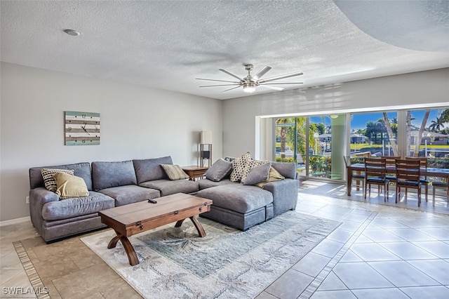 living room featuring ceiling fan and a textured ceiling