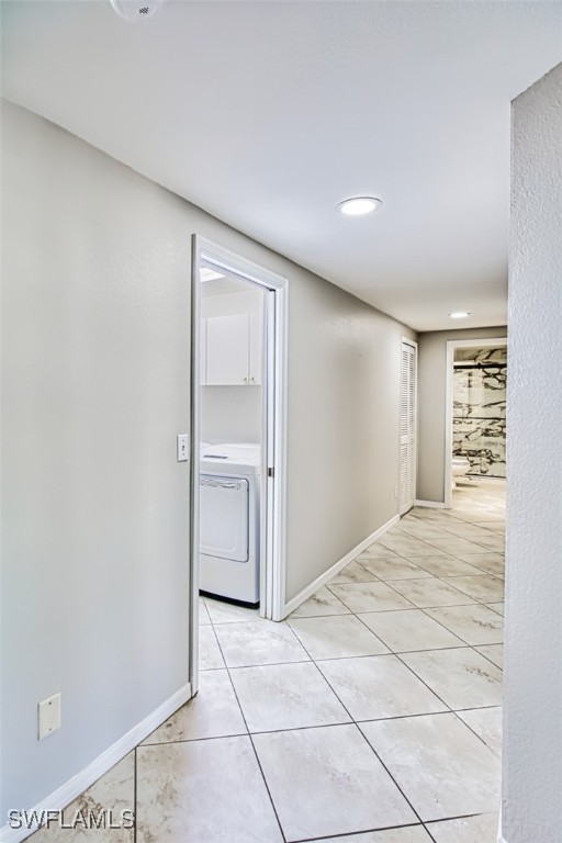 hallway with light tile patterned floors and washer / clothes dryer