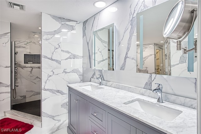 bathroom with a tile shower and vanity