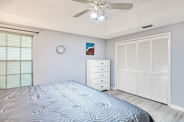 bedroom with a closet, ceiling fan, and light hardwood / wood-style floors