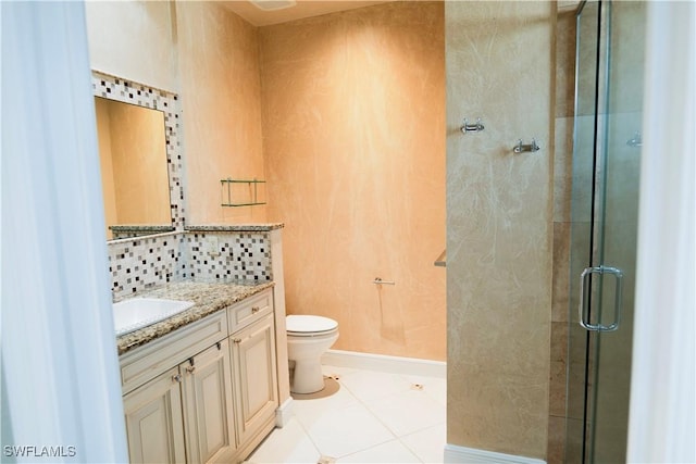 bathroom featuring tile patterned flooring, vanity, toilet, and walk in shower