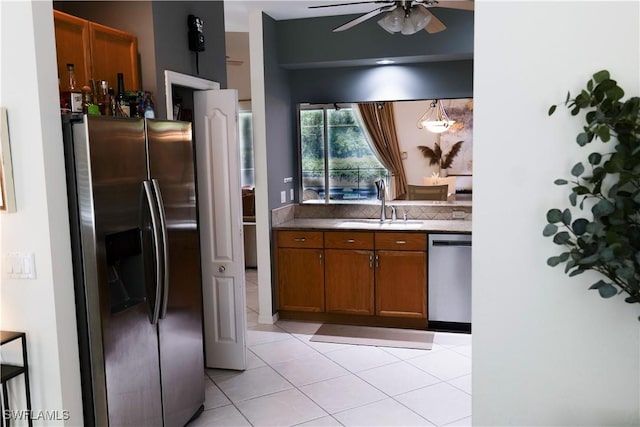 kitchen featuring appliances with stainless steel finishes, ceiling fan, sink, hanging light fixtures, and light tile patterned flooring