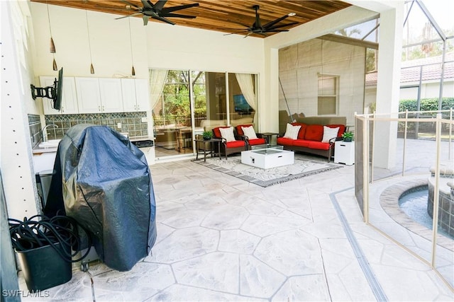 sunroom featuring ceiling fan and wooden ceiling