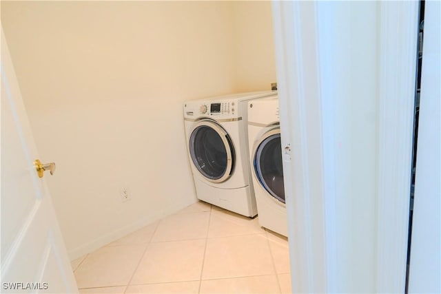 washroom featuring washing machine and dryer and light tile patterned floors