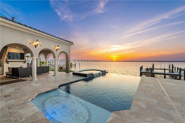 view of swimming pool with a patio, a boat dock, a water view, a pool with connected hot tub, and outdoor lounge area