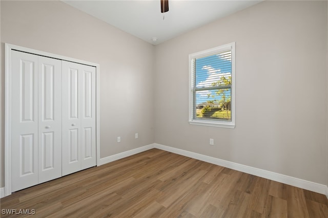 unfurnished bedroom featuring a closet, light hardwood / wood-style floors, and ceiling fan