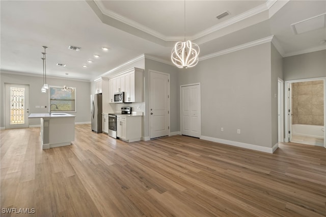 kitchen featuring crown molding, white cabinetry, pendant lighting, and stainless steel appliances