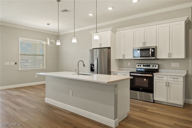 kitchen with a center island with sink, white cabinets, appliances with stainless steel finishes, decorative light fixtures, and light hardwood / wood-style floors