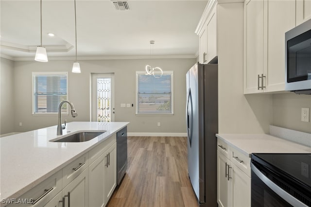 kitchen featuring white cabinets, stainless steel appliances, hanging light fixtures, and sink