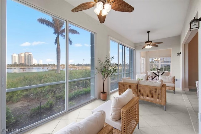 sunroom with ceiling fan and a water view