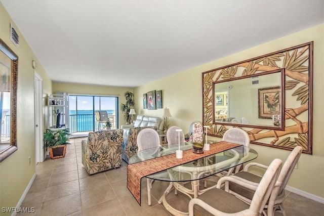 tiled dining area featuring a water view