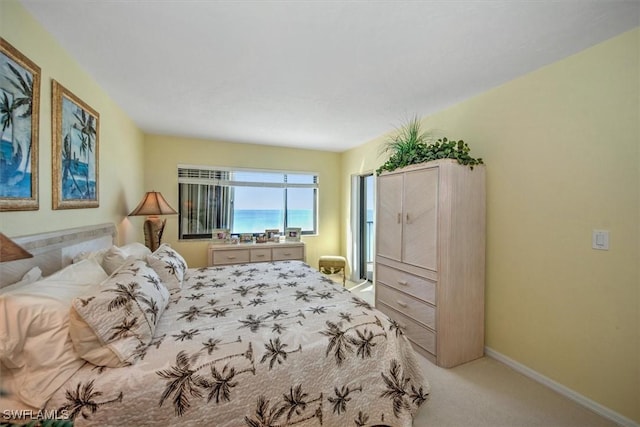 bedroom featuring light colored carpet and a water view