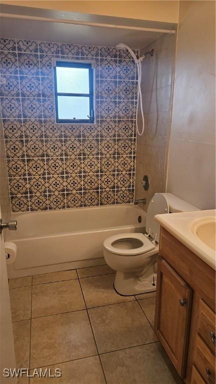 full bathroom with tile patterned flooring, vanity, tiled shower / bath combo, and toilet