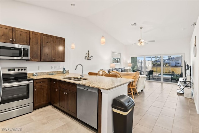 kitchen with kitchen peninsula, appliances with stainless steel finishes, ceiling fan, sink, and pendant lighting