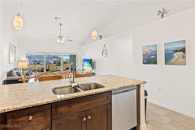 kitchen featuring pendant lighting, dishwasher, light stone countertops, and sink