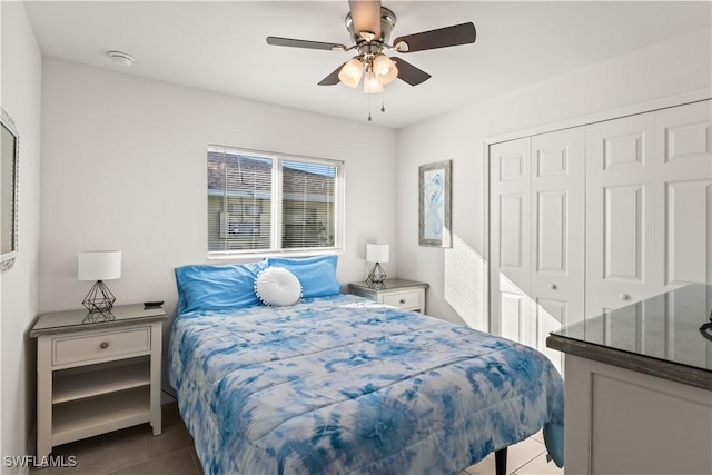 bedroom with ceiling fan, light tile patterned flooring, and a closet