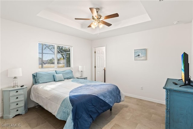 bedroom featuring a raised ceiling and ceiling fan