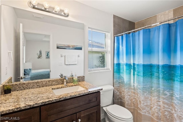 bathroom featuring curtained shower, vanity, and toilet