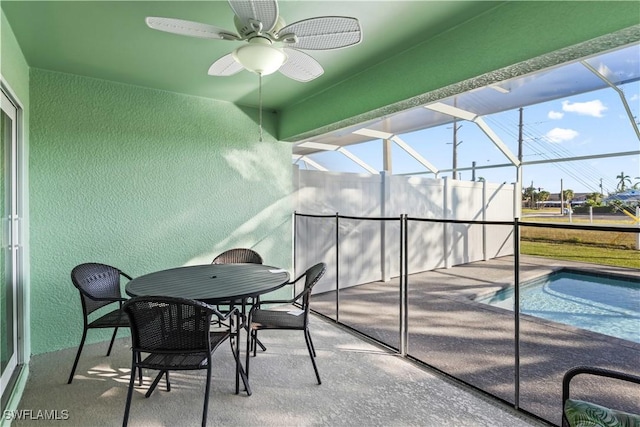 sunroom featuring ceiling fan and a swimming pool