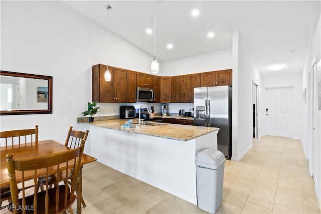 kitchen with sink, high vaulted ceiling, kitchen peninsula, pendant lighting, and appliances with stainless steel finishes