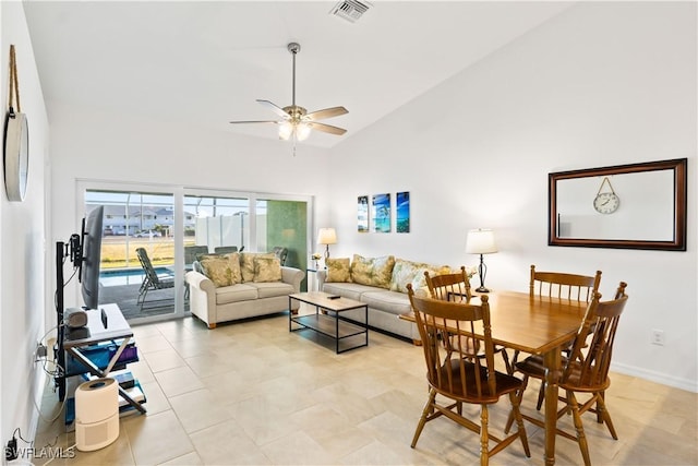 living room featuring ceiling fan, light tile patterned flooring, and a towering ceiling