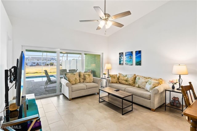 living room with ceiling fan and a towering ceiling