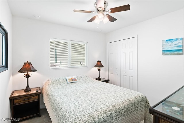 bedroom featuring light tile patterned floors, a closet, and ceiling fan