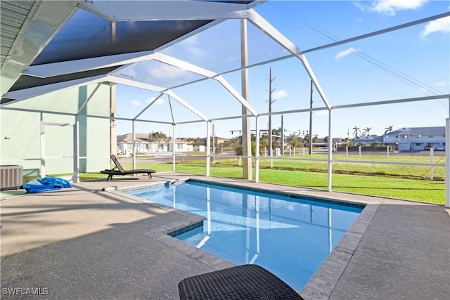 view of swimming pool with a lawn, glass enclosure, a patio area, and central air condition unit