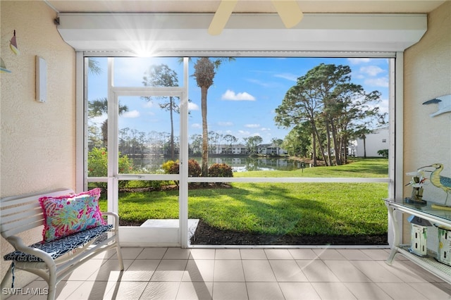 sunroom with a water view and ceiling fan