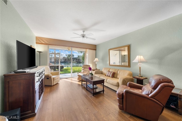 living room featuring light hardwood / wood-style floors and ceiling fan