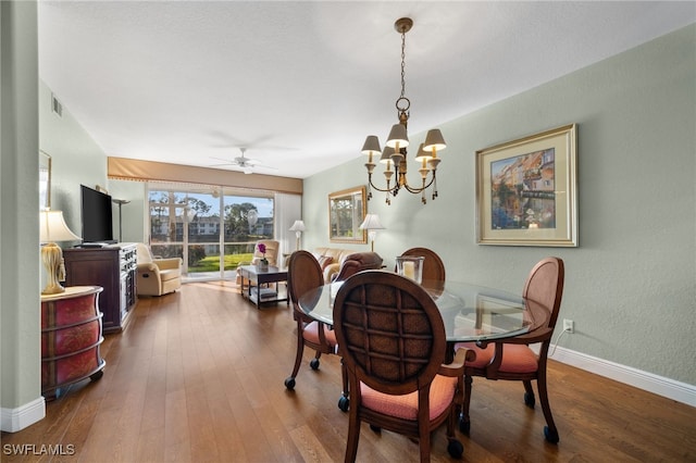 dining area featuring ceiling fan with notable chandelier and wood-type flooring