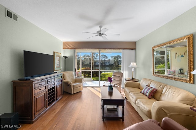 living room featuring wood-type flooring and ceiling fan