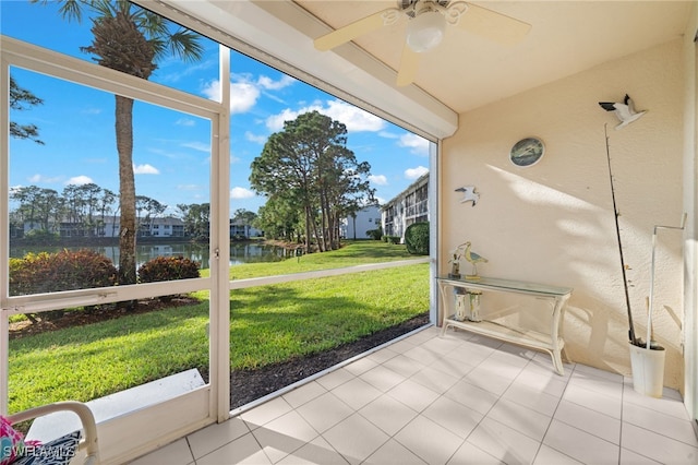 unfurnished sunroom featuring a water view and ceiling fan