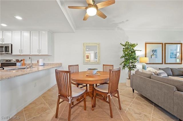 dining area with crown molding, sink, ceiling fan, and light tile patterned floors