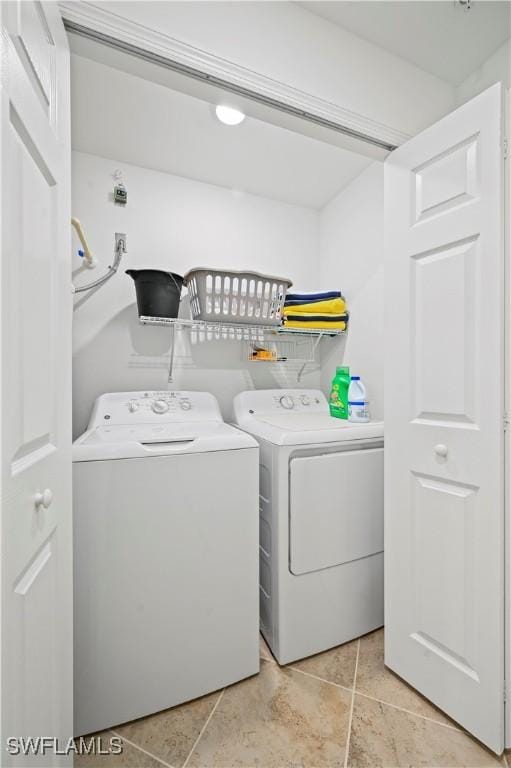 laundry area featuring light tile patterned floors and washing machine and clothes dryer