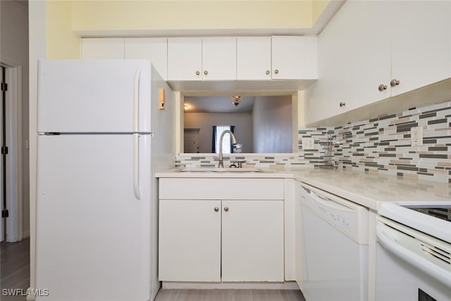 kitchen featuring white appliances, white cabinets, sink, decorative backsplash, and light wood-type flooring