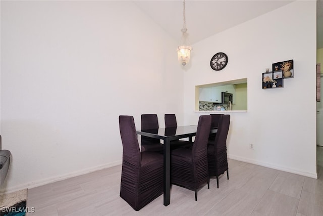 dining area with high vaulted ceiling