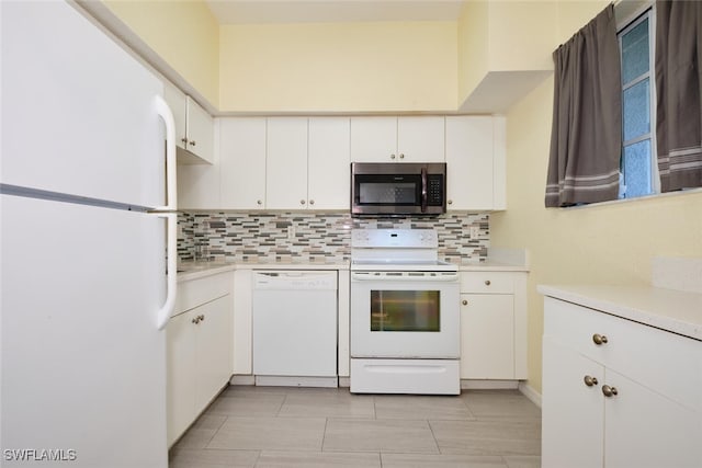 kitchen featuring white appliances, tasteful backsplash, and white cabinetry