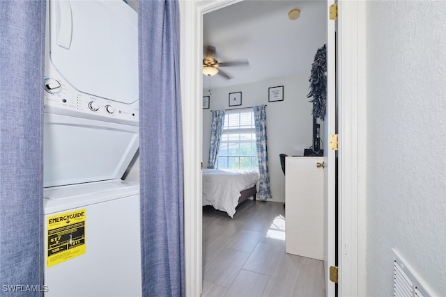 washroom with ceiling fan and stacked washer / drying machine