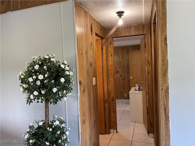 hallway featuring wood walls and light tile patterned flooring